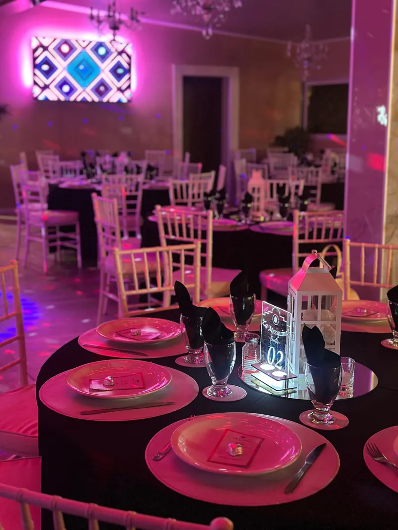 Mesas con sillas Tiffany bajo luces rosas