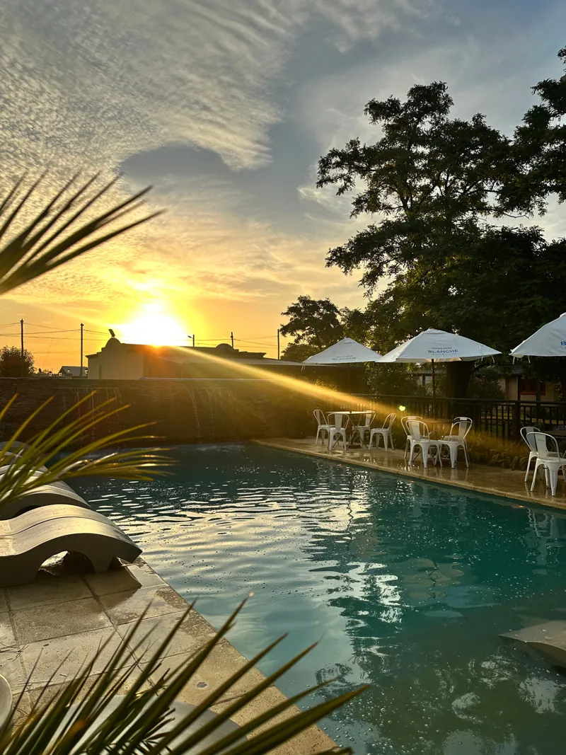 Pileta al atardecer con sombrillas